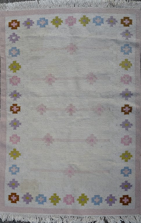 Rölakan tæppe med geometrisk mønster i forskellige nuancer. 
