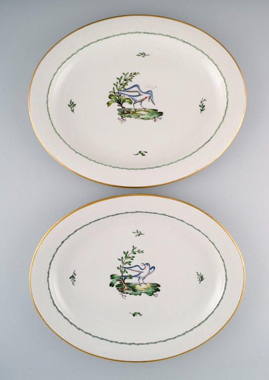 To store ovale Royal Copenhagen serveringsfade i håndmalet porcelæn med 
fuglemotiver og gulddekoration. Tidligt 1900-tallet. 
