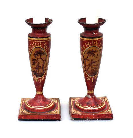 A pair of tin candle holders, red decorated with 
gildings