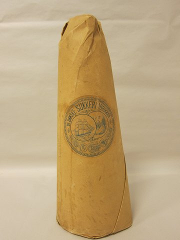 Sugar loaf with original contents and original paper
From "De Danske Sukkerfabrikker" (The Danish Sugarfactory)
H: 35cm, Diam. at the bottom: 14cm
In good condition