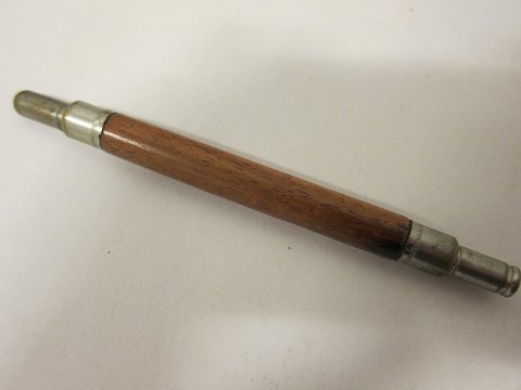 An old (pencil-)Holder/Handle made of wood with space for the pencil as well as 
the "top" of the fountain pen