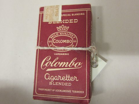 Cigarette case with the old Colombo cigarettes 
An old cigarette case  incl. the original cigarettes 
The original stamped revenue label is still intact with tax information and 
price
In a good condition
We have a large choice of old tobacco goods