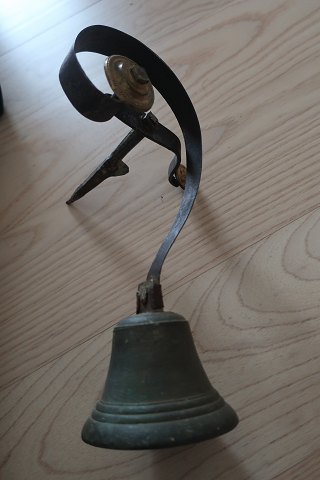 An antique bell used in a shop by the door
Bronce
The hanging is made by the iron 
About 1850
