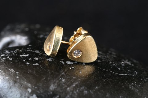 Stud earrings in 14 carat gold, with inlaid clear stone.