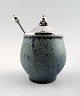 Arne Bang and others .: b. Frederiksberg 1901, d. Fensmark 1983.
Jam Jar in stoneware decorated with speckled blue-green glaze. 
Lid and spoon in sterling silver.