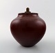 Royal Copenhagen Kresten Bloch oxblood glaze stoneware vase with bronze lid.
