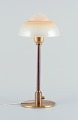 Fog & Mørup. Table lamp with a stem in patinated brass, fitted with a "Spejlæg" 
(Fried Egg) glass shade.