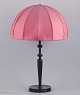 Josef Frank (1885-1967) for Svenskt Tenn, Sweden. Large Art Deco table lamp with 
a dark pink fabric shade and a black wooden base.