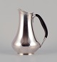 L'Art presents: 
Cohr, 
Denmark. 
Pitcher in 830 
silver. Handle 
made of 
precious wood.