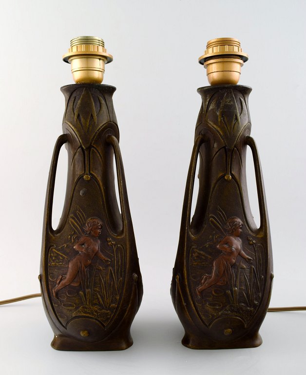 JEAN GARNIER (1853-1910) A pair of French Art Nouveau bronze table lamps, 
fairies in landscape.