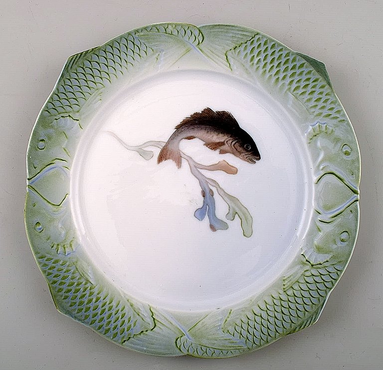 Arnold Krog for Royal Copenhagen : "Fiskestel" af porcelæn, middagstallerken 
dekoreret i farver med fisk.