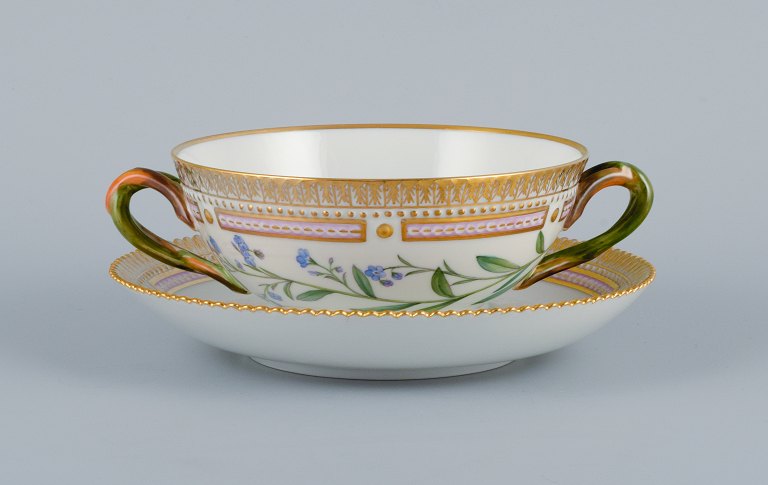 Royal Copenhagen Flora Danica boullionkop med underkop i håndmalet porcelæn med 
grenformede hanke, blomster og gulddekoration. 
PROVENIENS : VALDEMARS SLOT
Modelnummer 20/3612.  
