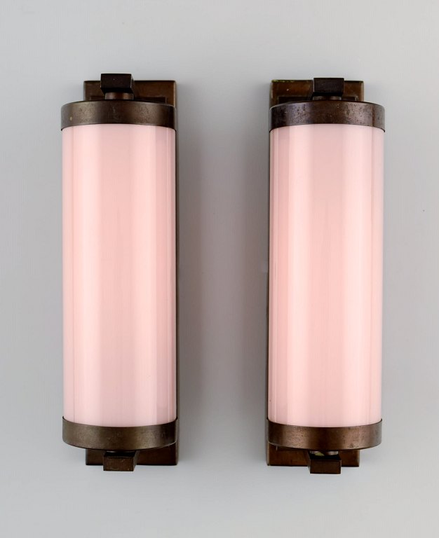 Skandinavisk designer, et par Art deco væglamper i messing med lyserøde 
glasskærme.