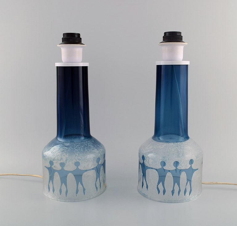 Ove Sandberg for Kosta Boda. Two table lamps in blue and clear art glass 
decorated with people. 1970s.
