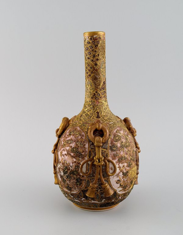 Meiji (1868–1912). Japanese satsuma bottle vase decorated in colors and gold 
with flowers in light relief.
