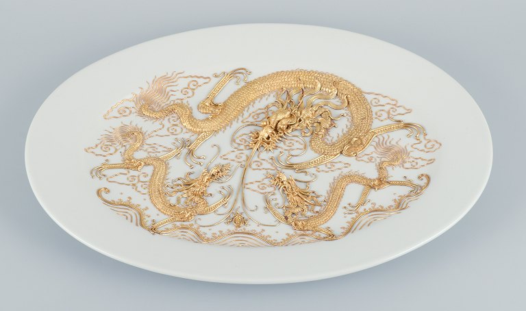 Stort ovalt porcelænsfad i Versace-stil, drager i relief.
Dekoreret med guldbelagt metal.