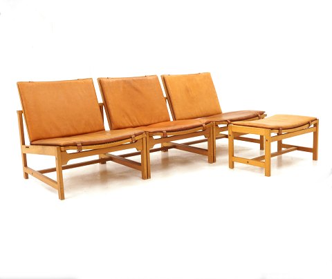 Arne Karlsen & Peter Hjort: Set of 3 lounge chairs 
and 1 stool, oak with leather. Danish Design. 
Presented in Milano 1961. L: 180cm. D: 70cm. Hs: 
30cm. H: 66cm