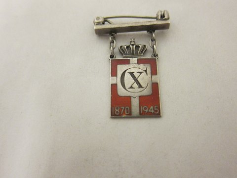Royal batch made of Sterling silver 925S with red enamel motif of the Dannebrog
This batch is made as a brooch with a beam
Year 1870-1945 is on as well as Christian X
The Silver smithy of Georg Jensen produced it in 1940-47