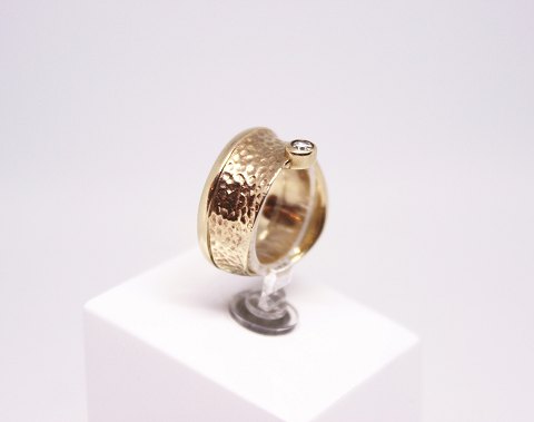 Hammerslået ring af 8 kt. guld dekoreret med zirkon og stemplet JAA.
5000m2 udstilling.