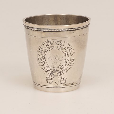 Søren Christensen, Varde, 1820-43: Lille Sølvbæger 
prydet med tre kartoucher, hvori stiliserede 
blomster og navnetræk i laurbærkrans. Dateret 
1826. H: 6,5cm. V: 74gr