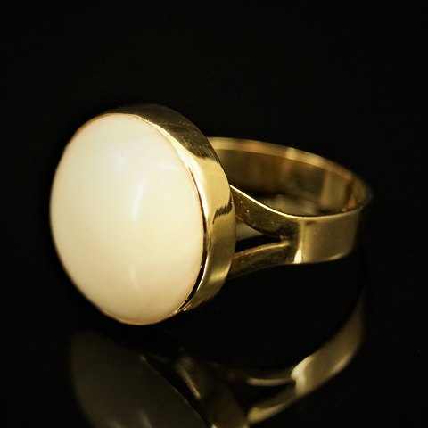 A ring of 18k gold with a coral