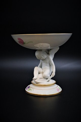 Antique Royal Copenhagen bowl on foot 
with little angel sitting on a dolphin from 1850-70. 
H:15,5cm. Dia.:16cm.
