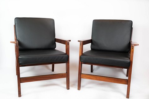 A pair of lounge chairs in polished wood and black classic leather of danish 
design from the 1960s.
5000m2 showroom.