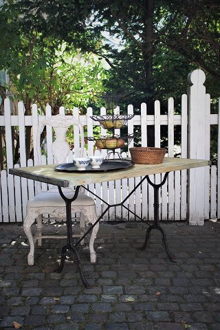 Old French bistro / café table with , consisting of a base in black cast iron 
and a top plate of old wooden planks...