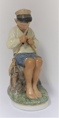 Royal Copenhagen. Porcelain figure. Seated boy in colors. Model 905. Height 19 
cm. (1 quality)