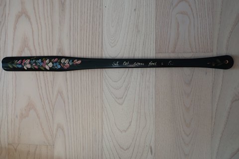 Vintage helper to take the shoes on - long model
Made of wood
Black original colour with decoration with flowers and text: "Så let som fod i 
hose"