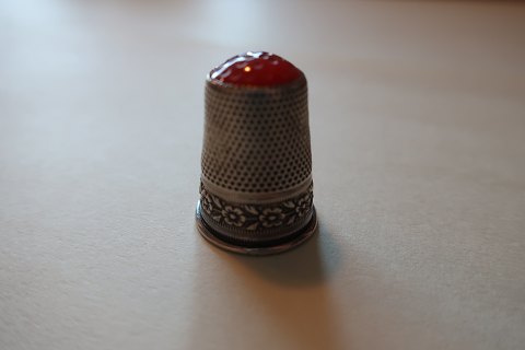 Old thimbles made of silver
With a red fluss
No stamps
Decoration in the silver like a runner of flowers