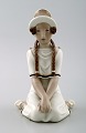 Arno Malinowski for Royal Copenhagen.
Sitting girl with braids. Overglaze.