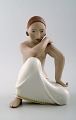 Rare Arno Malinowski for Royal Copenhagen.
Seated half-naked woman with art deco haircut. Overglaze.