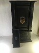 Stentoft Antik 
presents: 
Old unique 
safe in 
miniature. 
standing on 
wooden shelf. 
with 2 drawers.
gate with ...