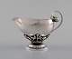 Georg Jensen: Pitcher of sterling silver, forged with flower buds and pierced 
stem with leaves.