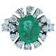 An emerald ring with diamonds mounted in 14k white gold
