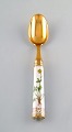 Michelsen for Royal Copenhagen. "Flora Danica" dinner spoon of gold plated 
sterling silver. Porcelain handle decorated in colors and gold with flowers.