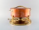 Jens H. Quistgaard. Fondue pot in brass and copper pot on stand with burner.