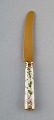 Georg Jensen for Royal Copenhagen. "Flora Danica" dinner knife of gold plated 
sterling silver. Porcelain handle decorated in colors and gold with flowers.
