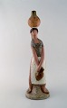 Lladro, Spain. Large figure in glazed ceramics. Woman carrying water. Late 20th 
century.
