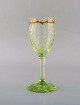 Emile Gallé (1846-1904). Tidligt og sjældent vinglas i mundblæst lysegrønt 
kunstglas med håndmalede guldekorationer i form af blade. Museumskvalitet, 
1870/80