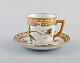 Royal Copenhagen coffee cup with saucer in hand-painted porcelain with gold 
decoration and flowers. Flora danica style, 1960s.
