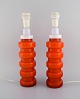 PO Ström for Alsterfors. Two table lamps in orange mouth blown art glass. 
Swedish design, 1960s.
