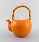 Kenji Fujita for Tackett Associates. Tekande i porcelæn med bambushank. Smuk 
orange glasur. Dateret 1953-56.
