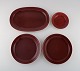 Royal Copenhagen / Aluminia Confetti plate and three large dishes in burgundy 
red glazed faience. Mid-20th century.
