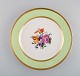 Royal Copenhagen tallerken i håndmalet porcelæn med blomstermotiv og kant i 
lysegrøn og guld. Dateret 1958.
