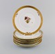 Seven Royal Copenhagen Golden Basket porcelain lunch plates with flowers and 
gold decoration. Model number 595/10521.
