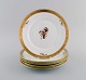Five Royal Copenhagen Golden Basket plates in porcelain with flowers and gold 
decoration. Model number 595/9589.

