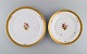 To runde Royal Copenhagen Guldkurv serveringsfade i porcelæn med blomster og 
gulddekoration. Tidligt 1900-tallet.
