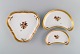 Three Royal Copenhagen Golden Basket dishes in porcelain with flowers and gold 
decoration. Early 20th century.
